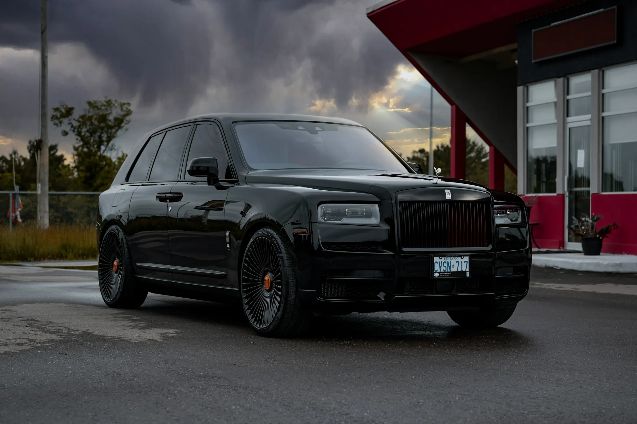 Rolls-Royce Cullinan at the entrance of a downtown Vancouver hotel in the evening