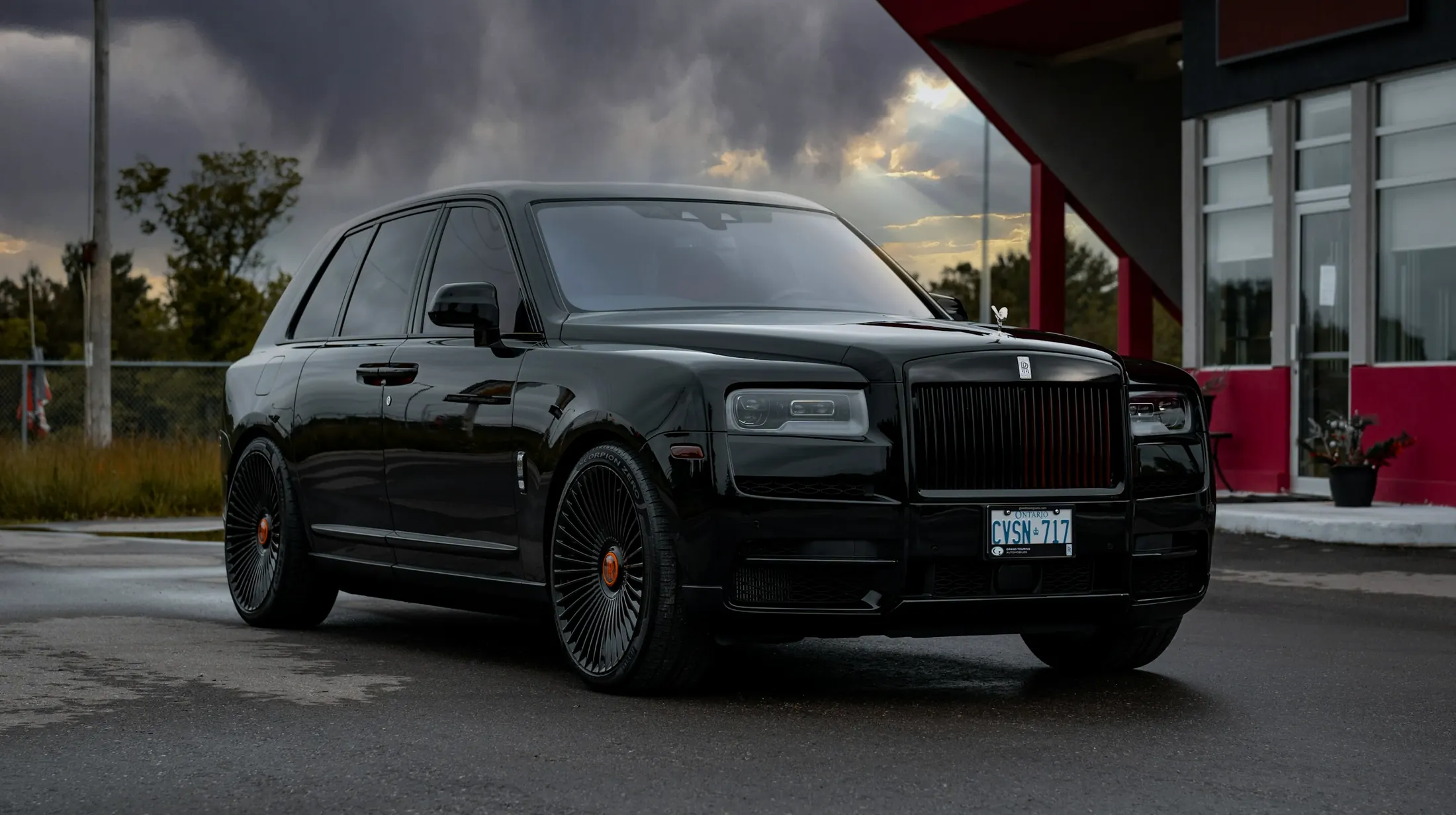 Rolls-Royce Cullinan at the entrance of a downtown Vancouver hotel in the evening