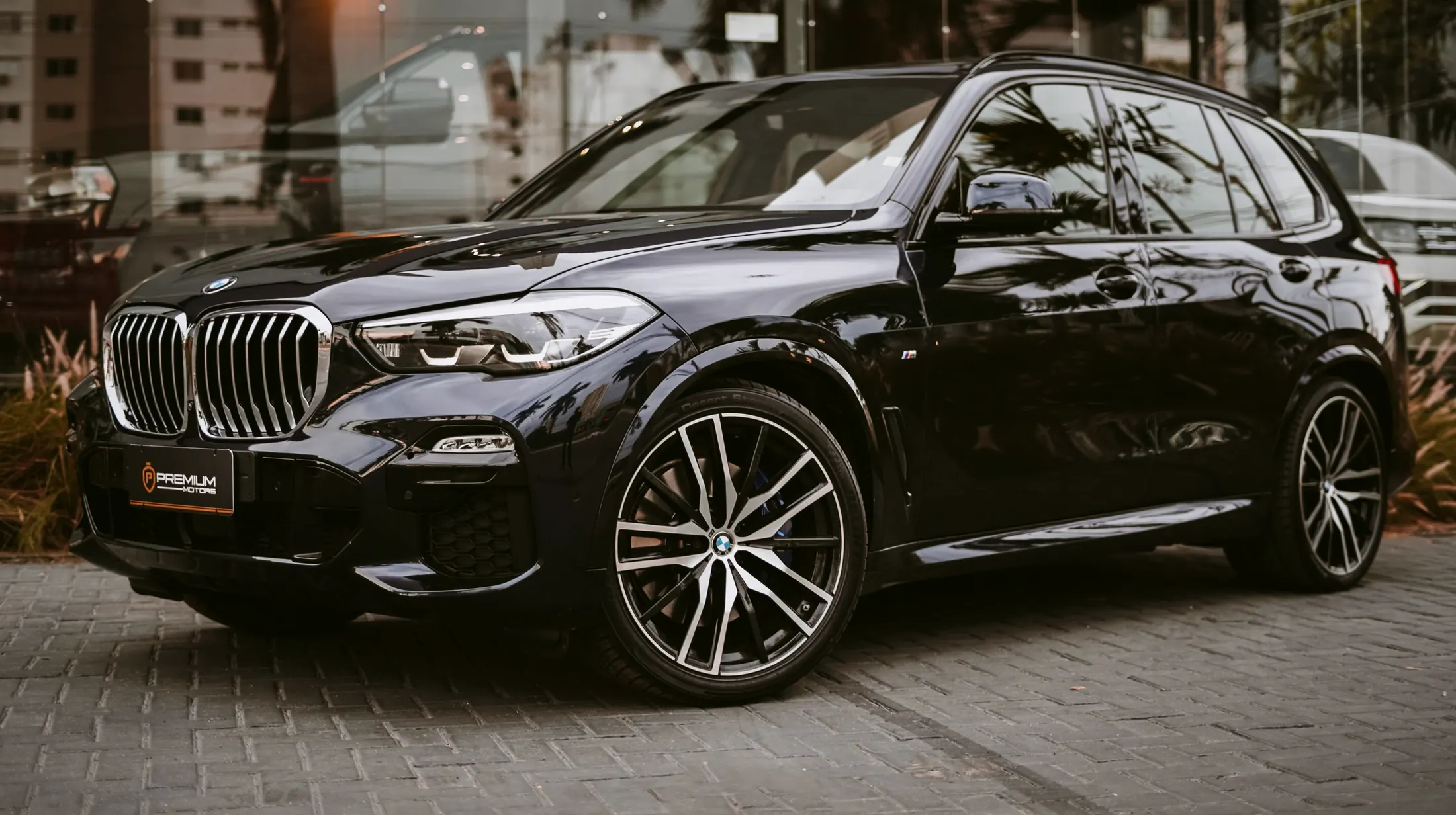 BMW X5 40i parked on a quiet street in Coal Harbour, Vancouver, with the North Shore mountains behind